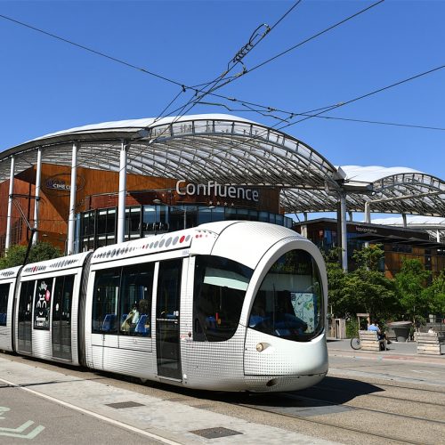 Tramway in a street of Lyon, France. Lyon, France-06 25 2022: Tramway passing in front of the Confluence shopping center in the Confluence district of Lyon, France.