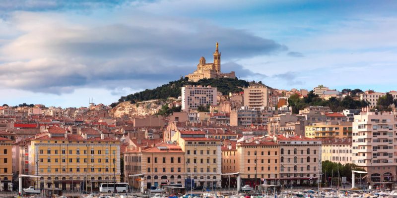 The old Vieux Port and Basilica Notre Dame de la Garde in the historical city center of Marseilles on sunny day, France