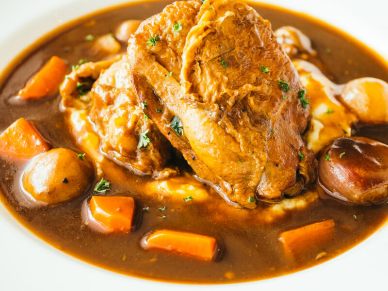 Roast chicken with red wine sauce in white plate